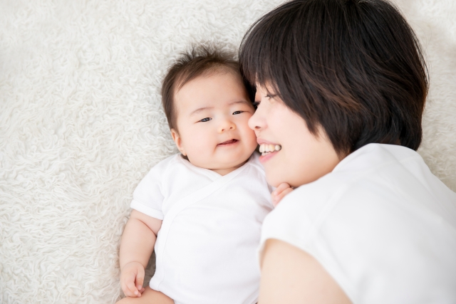 赤ちゃんに頬を寄せてほほ笑むママ